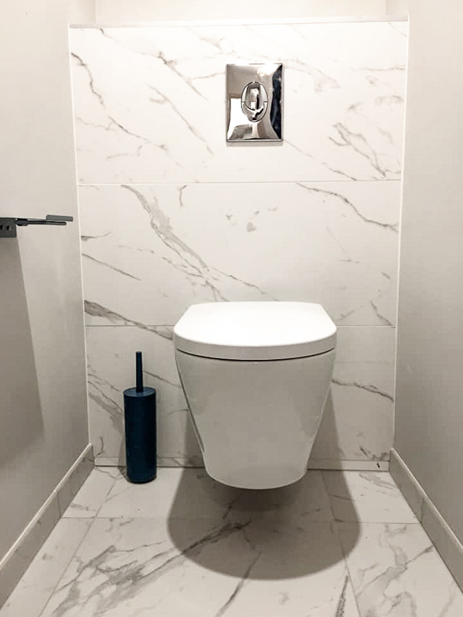 Installation de toilettes suspendus avec carrelage et faïence murale esprit marbre par HLG PLOMBERIE